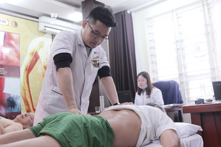 Bác sĩ Trần Hải Long thực hiện xoa bóp, bấm huyệt cho bệnh nhân 